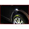 Close-up van een bruine auto met het wiel en de zijmarkeringslicht.